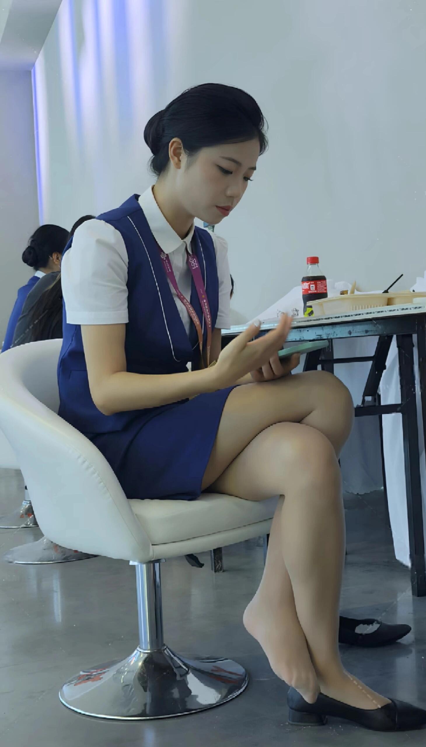 woman in uniform wearing mobile phone while eating