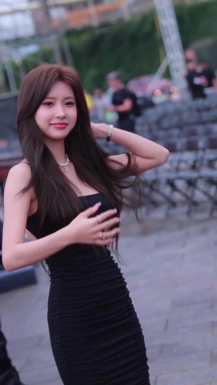 woman in black dress lifts her hair